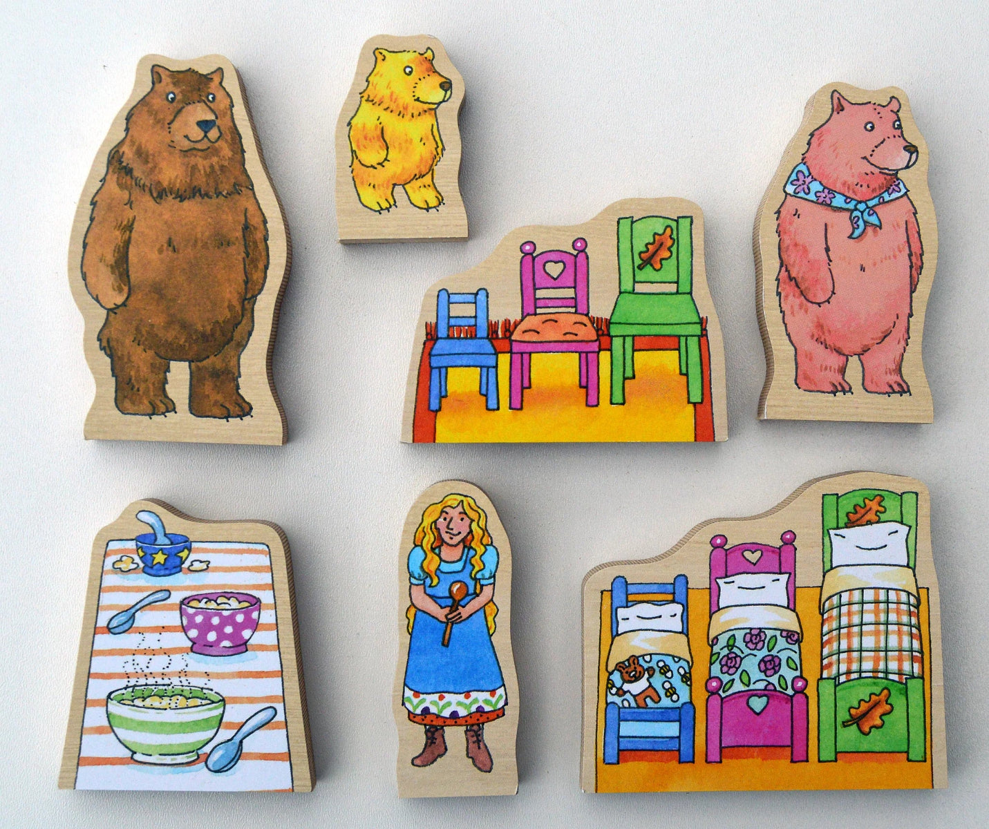 Set of wooden bear family and furniture pieces on a white background