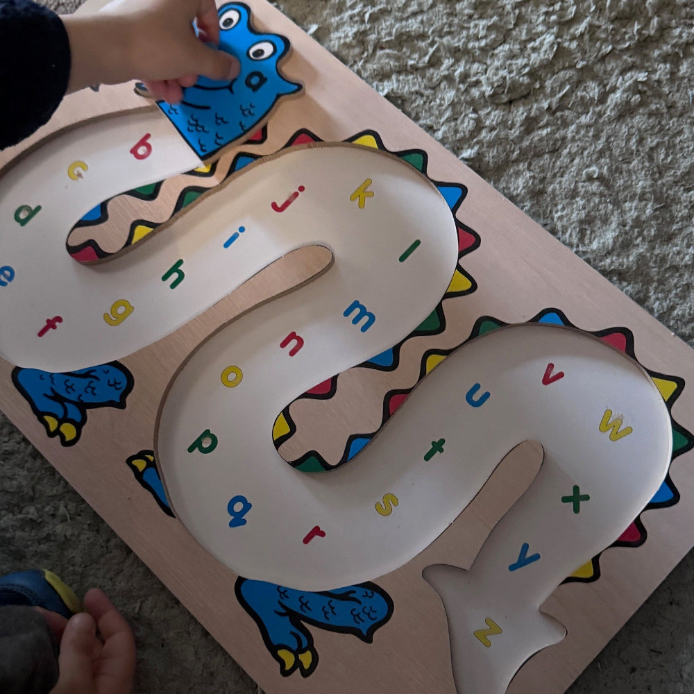 Children's educational mat with colorful letters and shapes on a carpeted floor.
