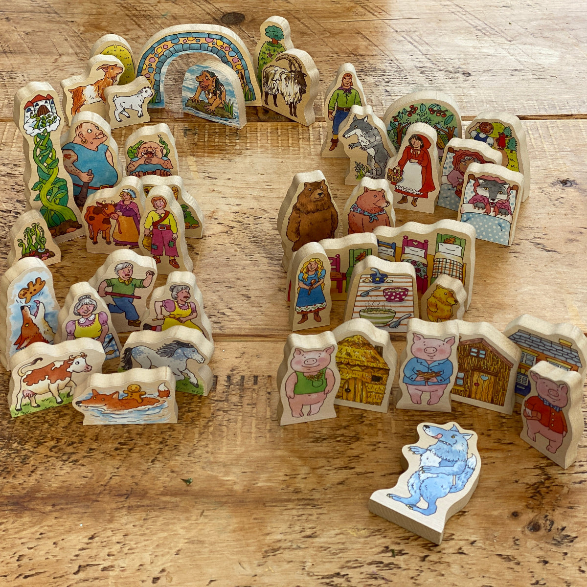 Set of wooden traditional tales story scene pieces on a wooden surface
