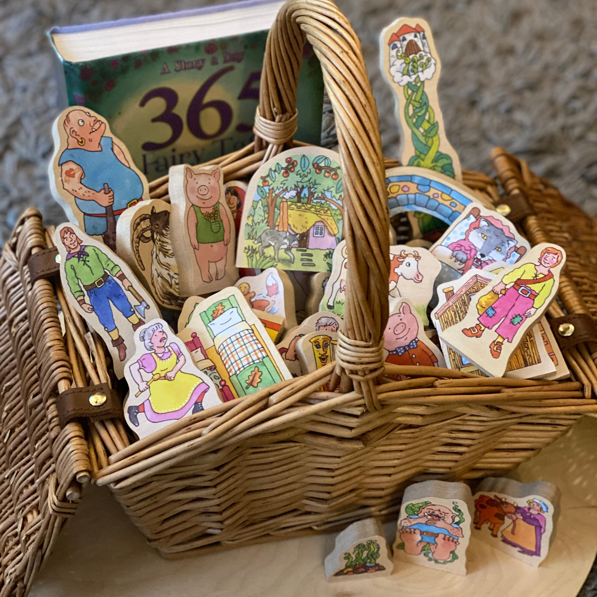 Wicker basket with wooden classic story characters featuring illustrations of people and scenes on a textured surface.