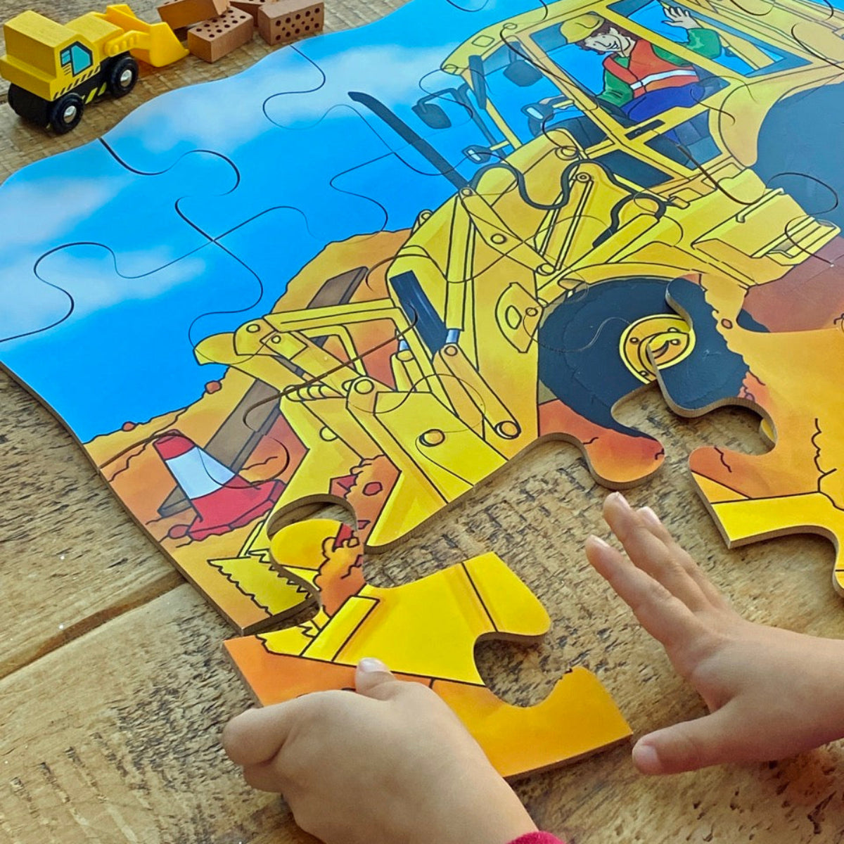 Children's puzzle with a construction theme digger on a wooden surface