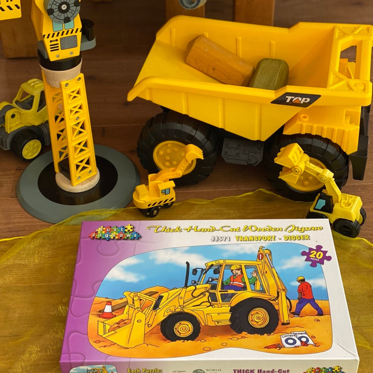 Toy construction vehicle set with a puzzle box featuring a bulldozer on a yellow surface.