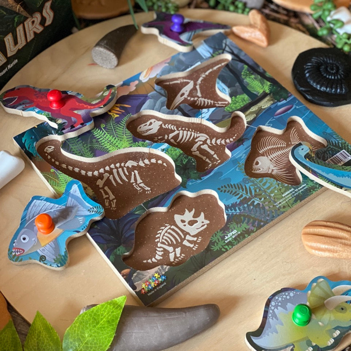 Dinosaur-themed wooden puzzle on a table with decorative elements