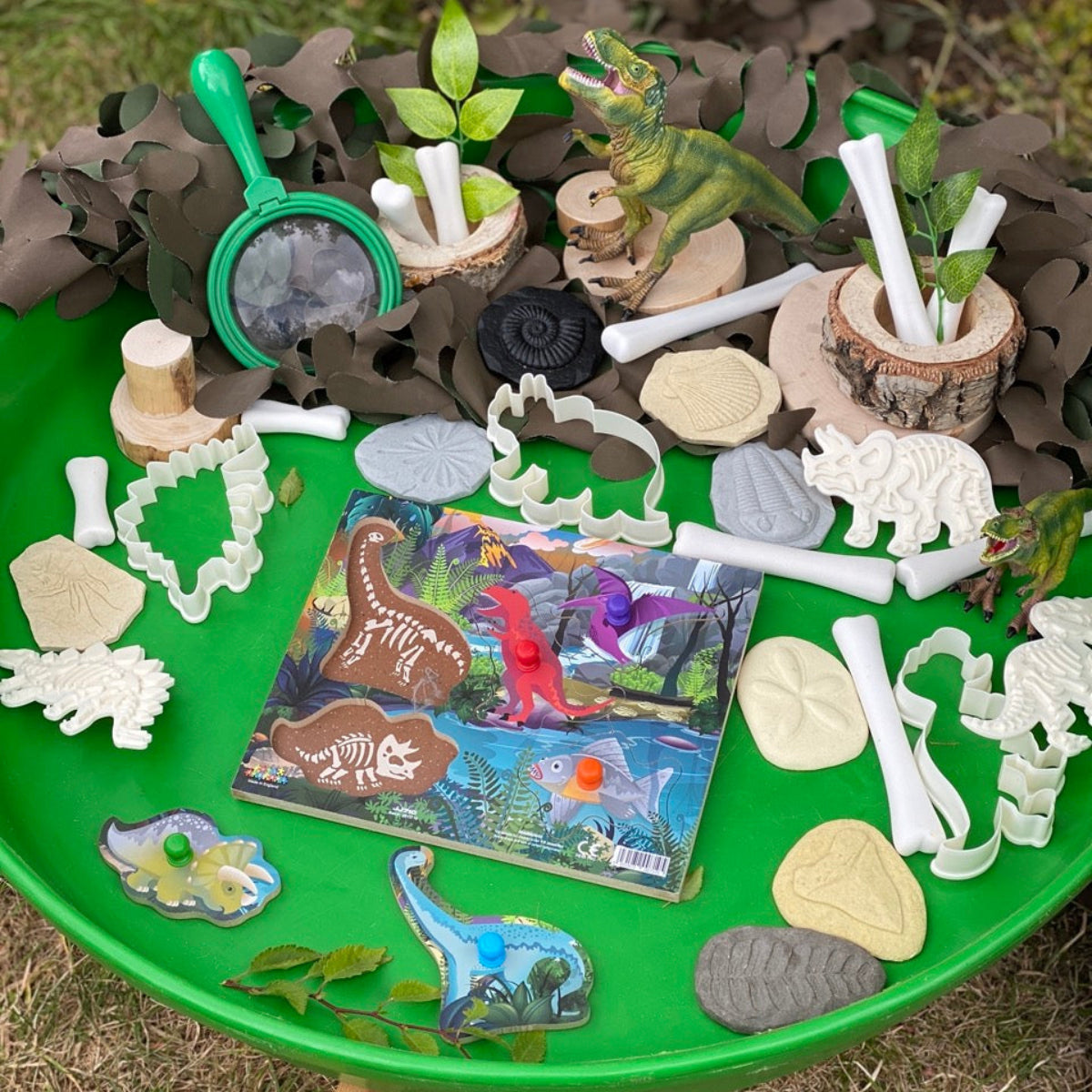 Dinosaur-themed peg puzzle on a green tray outdoors