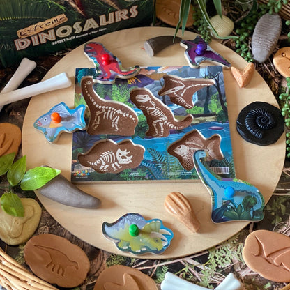 Dinosaur fossil -t hemed playset with toy figures and packaging on a wooden surface.
