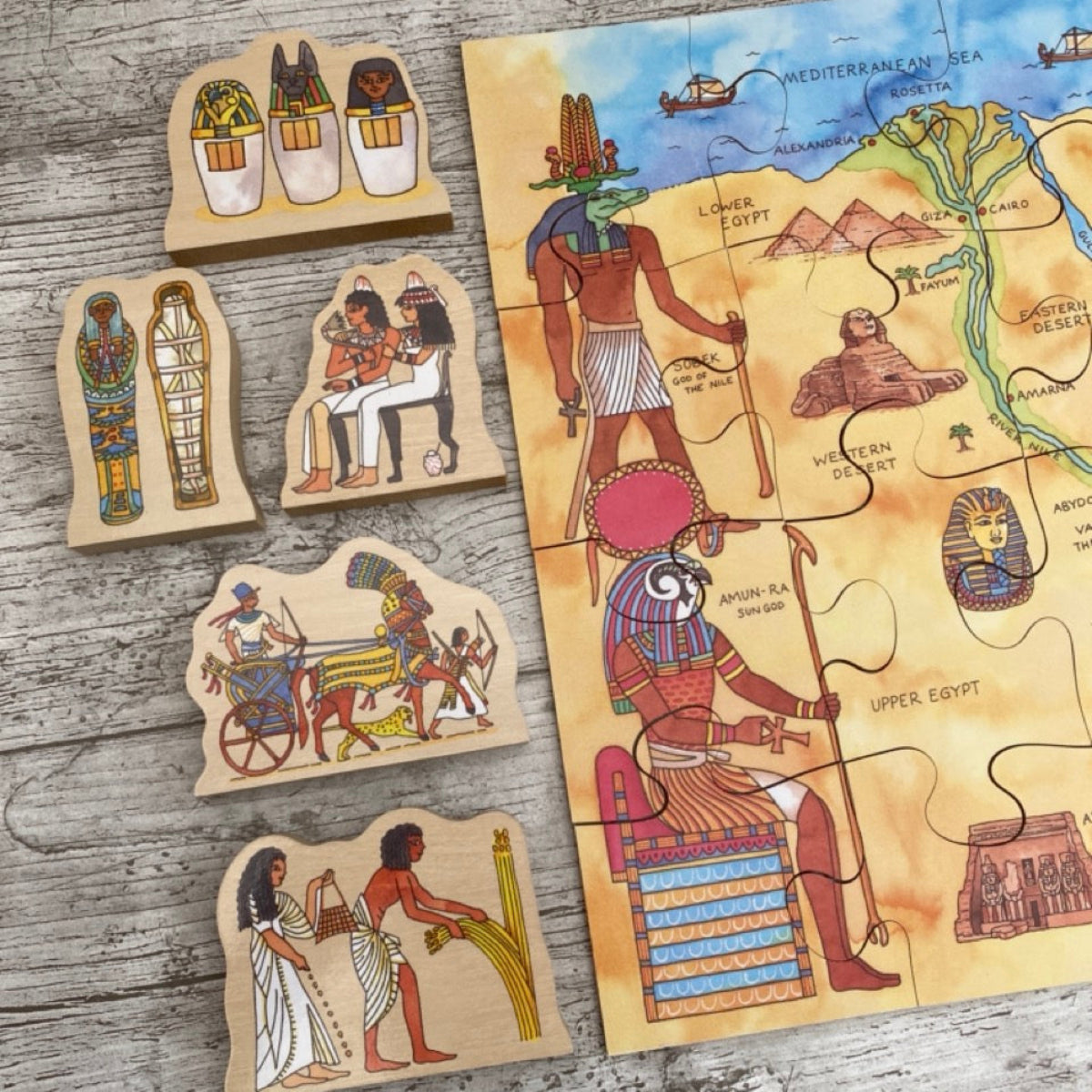 Set of wooden Egyptian-themed puzzle pieces on a wooden surface