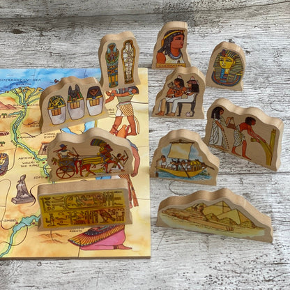 Set of wooden Egyptian-themed puzzle pieces on a wooden surface