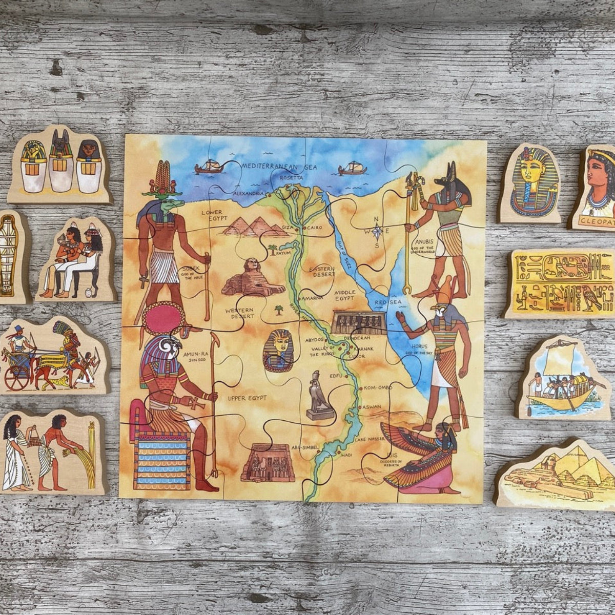 Egyptian-themed puzzle with pieces on a wooden surface