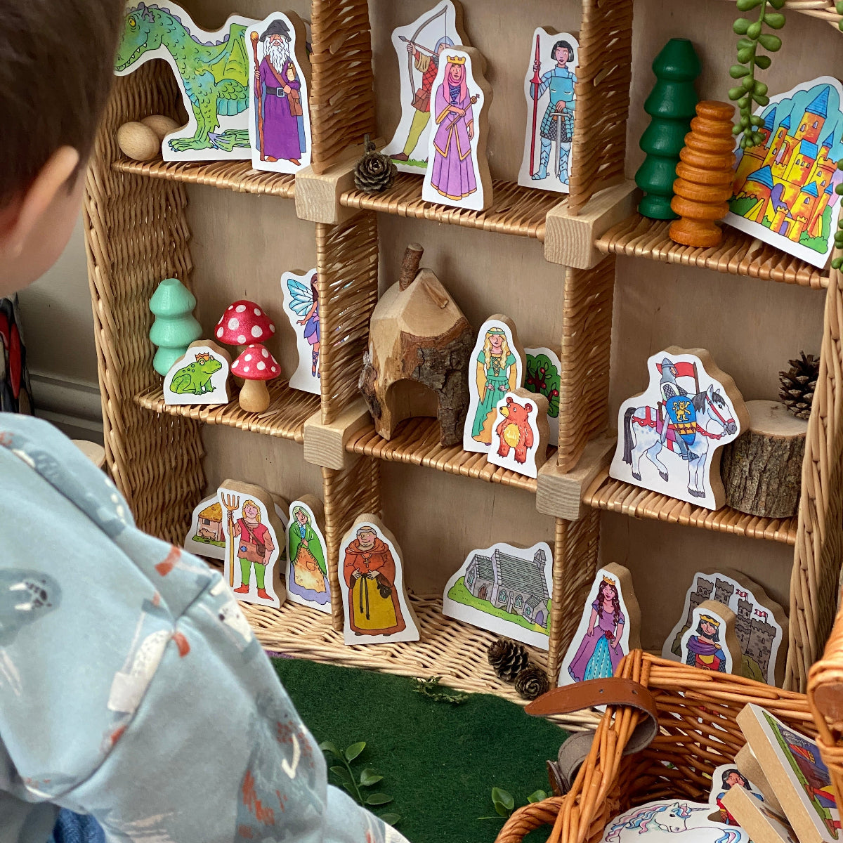 Children's play area with wicker shelves and colorful toys. Fairytale figures in small world play