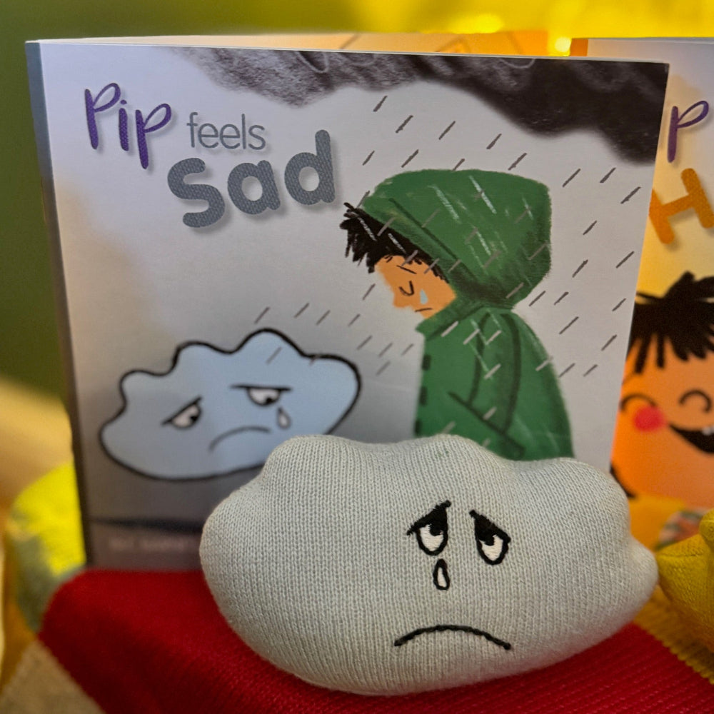Plush toy with sad expression and a book behind it.