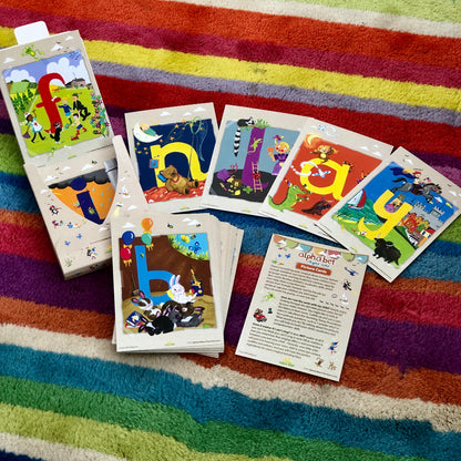 Children's alphabet flashcards on a colorful striped rug