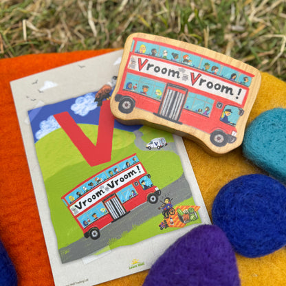Wooden toy bus with 'Vroom Vroom!' text on a grassy background