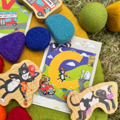 Colorful educational toys with animal shapes and a letter 'C' card on a grassy background