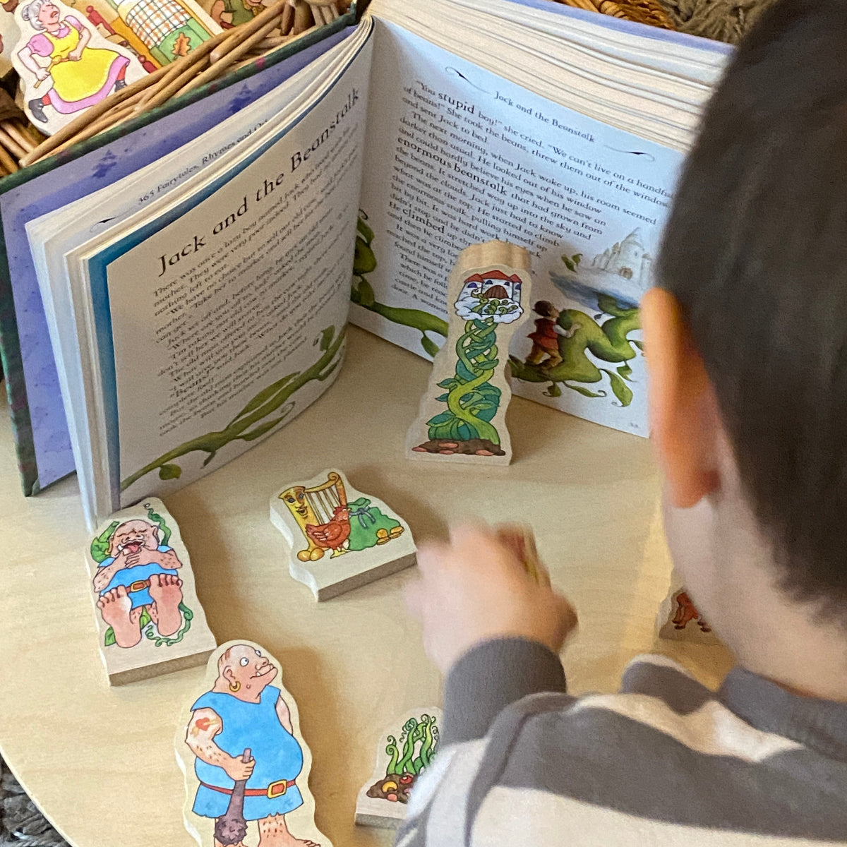 Child playing with illustrated story figures on an open book