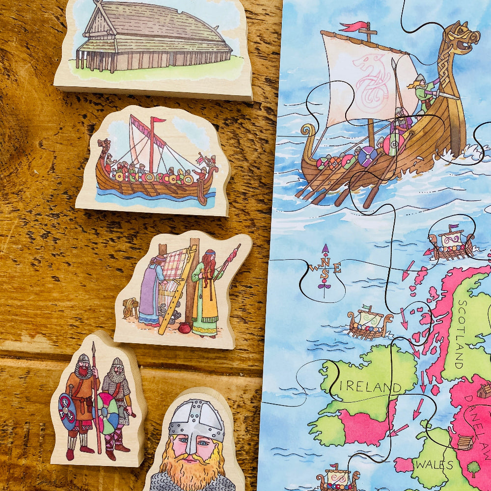 Set of Viking-themed wooden pieces on a wooden surface with a map of Ireland.