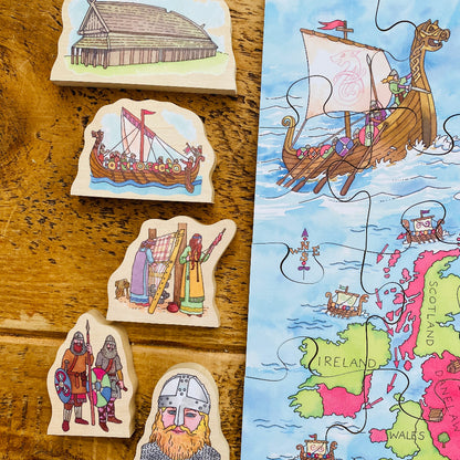 Set of Viking-themed wooden pieces on a wooden surface with a map of Ireland.