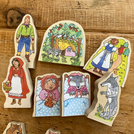 Wooden fairy tale characters on a wooden surface. Little Red Riding Hood