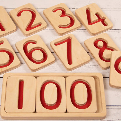 Wooden number trays with red numbers on a wooden surface