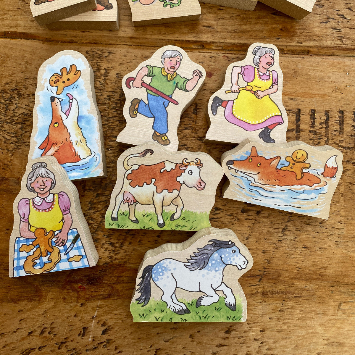 Wooden toys with colorful illustrations of animals and people on a wooden surface