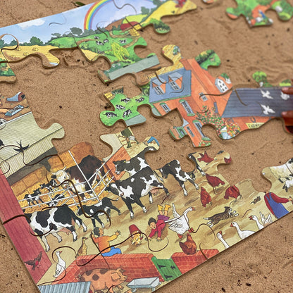 Partial puzzle of a farm scene on a sandy surface