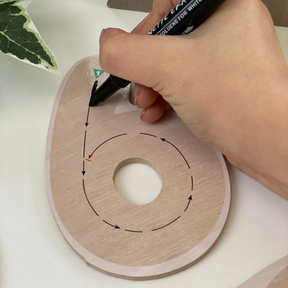 Hand using a marker to draw on a number 6
