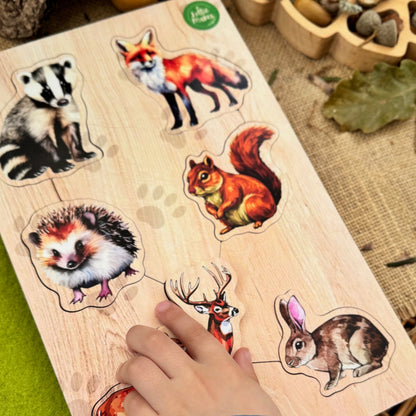 Wooden puzzle with forest animal illustrations on a wooden board, with a hand interacting with it.