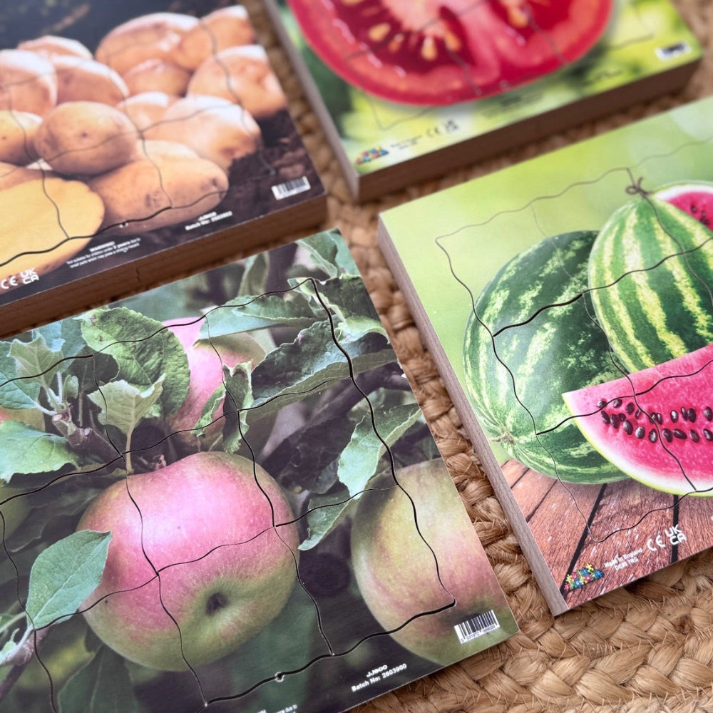 Four puzzle pieces with images of fruits and vegetables on a woven surface