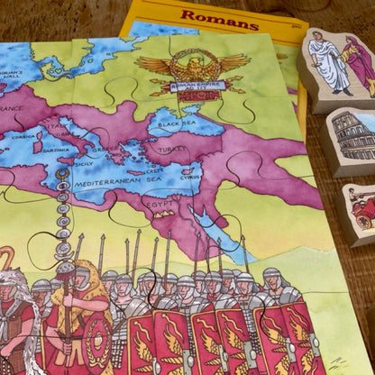 Educational Roman-themed game with map and character pieces on a wooden surface