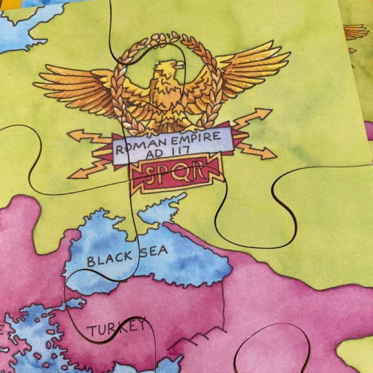 Map of the Roman Empire with an eagle emblem and text, colored in shades of yellow, blue, and purple.