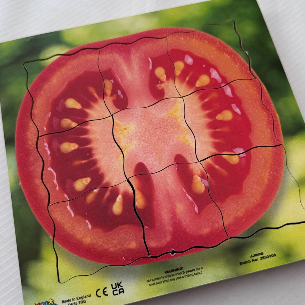 Puzzle of a sliced tomato on a green background